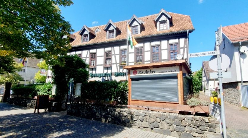 Historisches Fachwerkhaus mit dem Schild "Eis Anker" und dem Straßenschild "Philipsruher Allee" im Vordergrund.